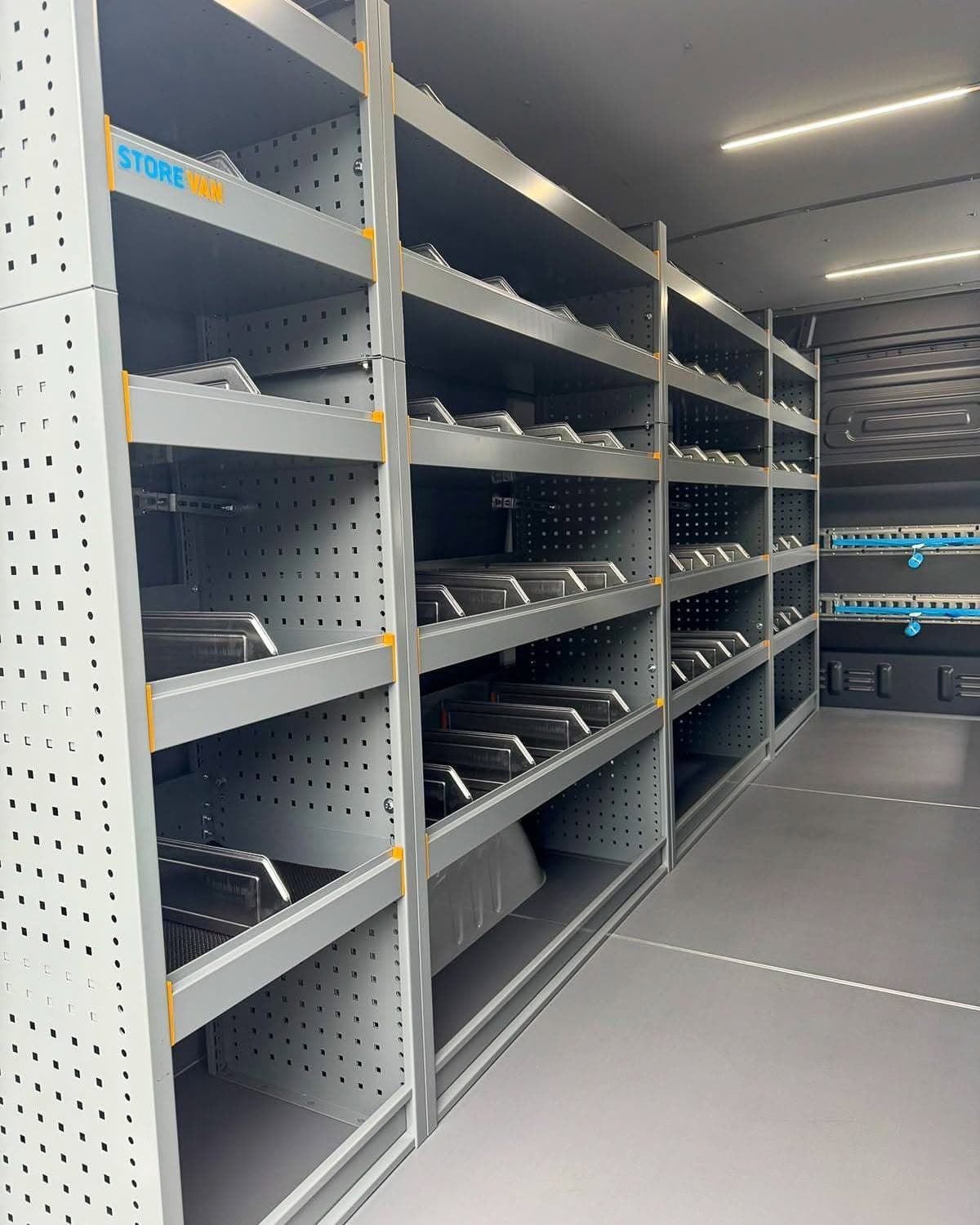 Rayonnage Store Van à séparateurs sur toute la longueur d'une paroi, rails d'arrimage à sangles bleues contre la cloison