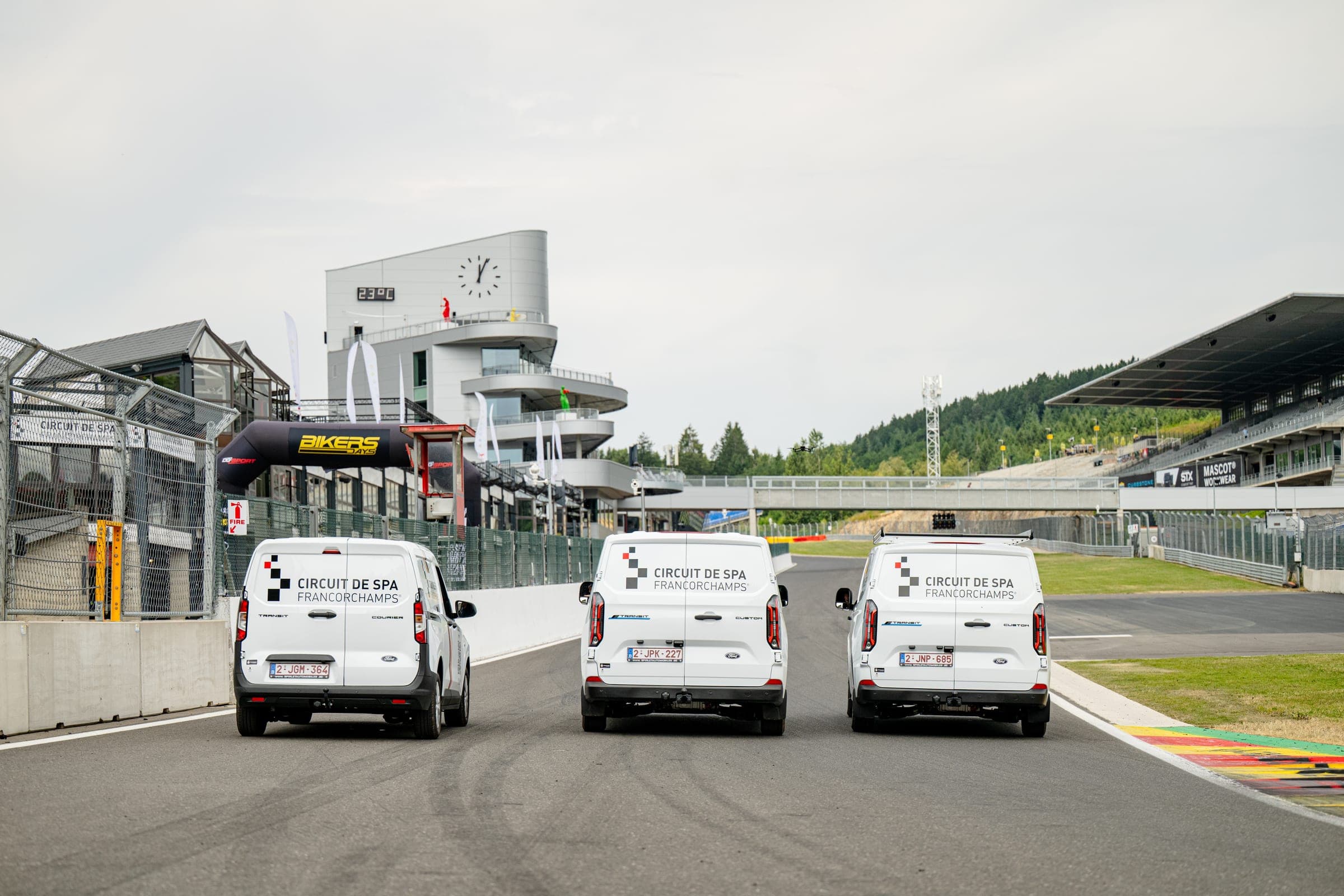Les trois utilitaires du circuit de Spa-Francorchamps vus de dos, lettrés aux couleurs du circuit