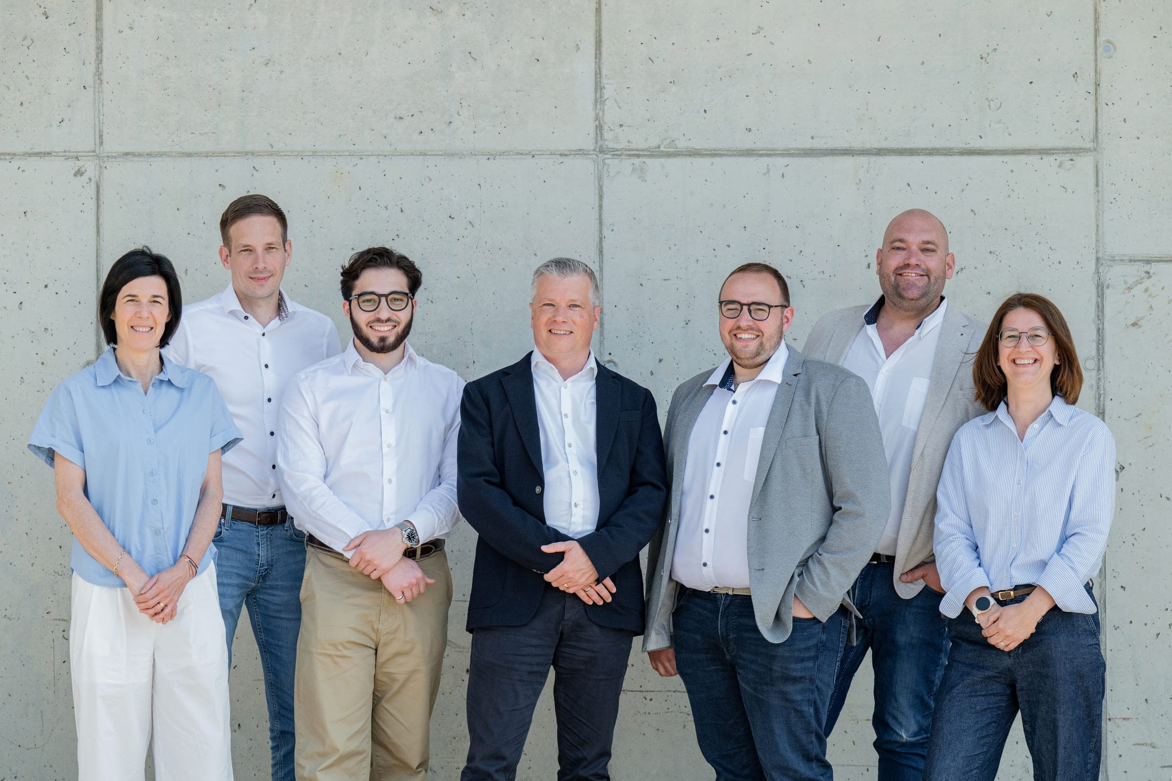Les sept collaborateurs du bureau d’Amecam Van Conversion, en chemise, devant les ateliers de Francorchamps