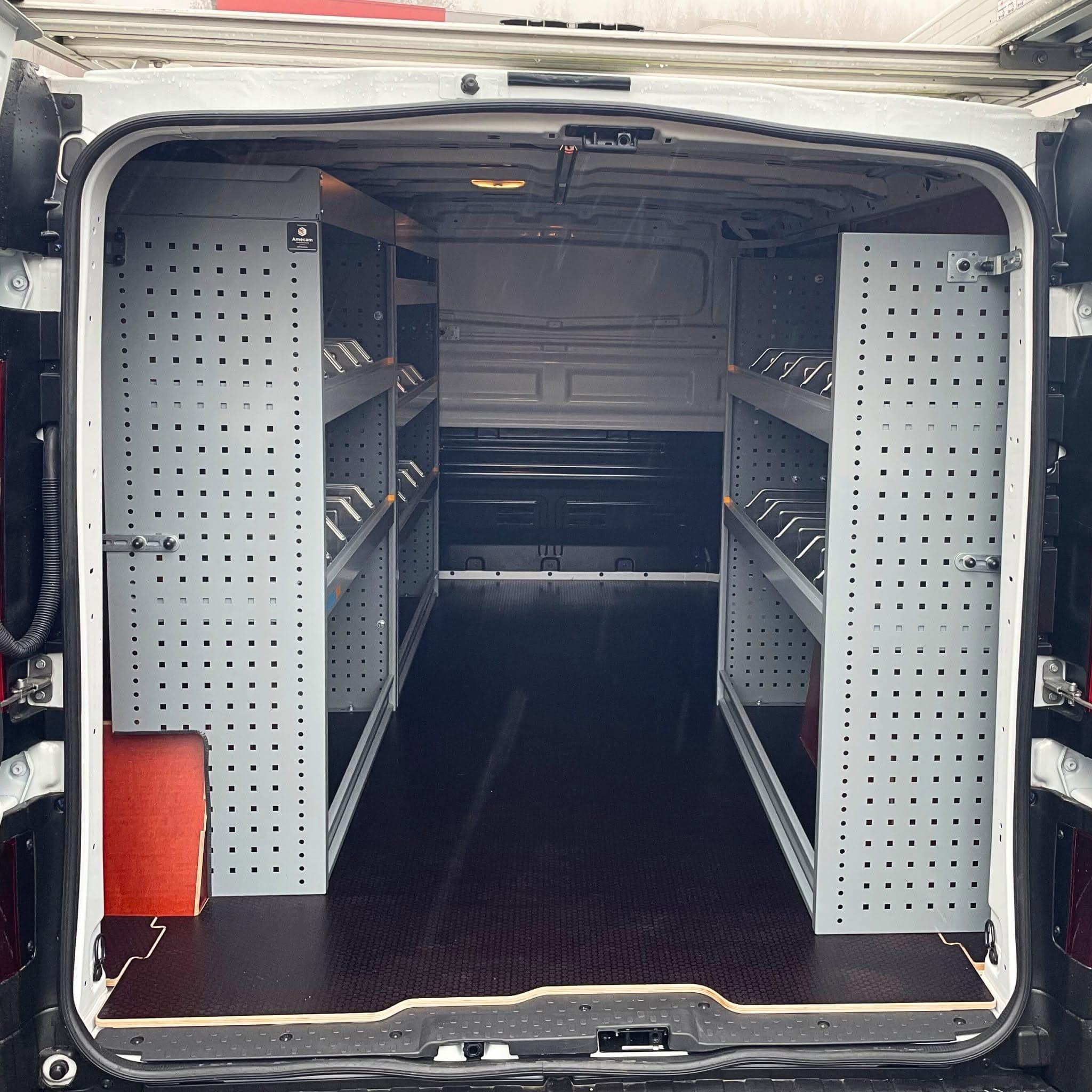 Zone de chargement du Renault Trafic d'ATI vue des portes arrière, rayonnages Store Van gris des deux côtés et plancher antidérapant noir