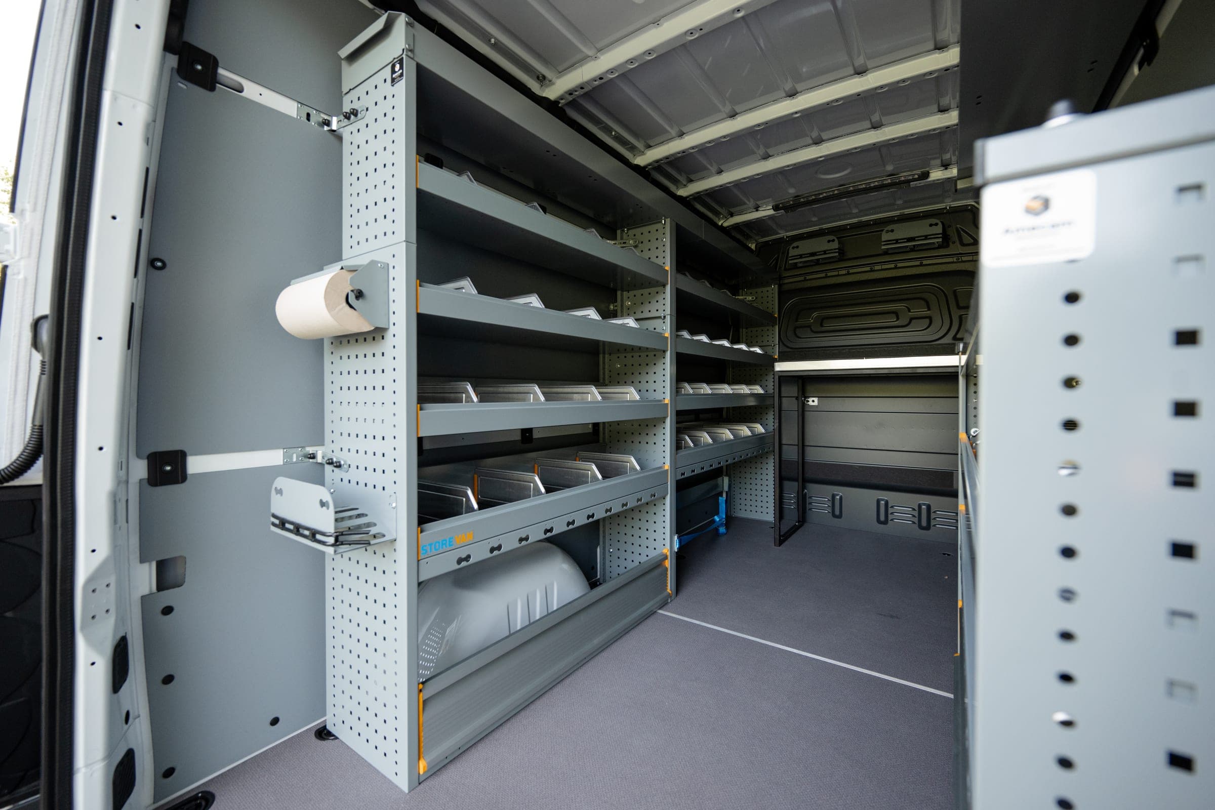 Aménagement intérieur de fourgon : rayonnage à étagères, armoire à tiroirs et panneau perforé porte-outils