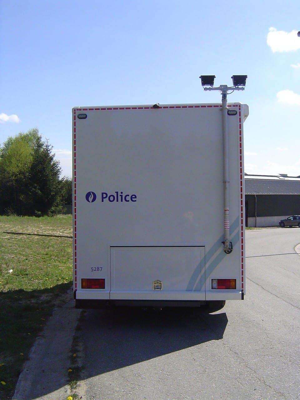 Remorque de contrôle de police blanche équipée d’un mât porteur de caméras, vue de l’arrière