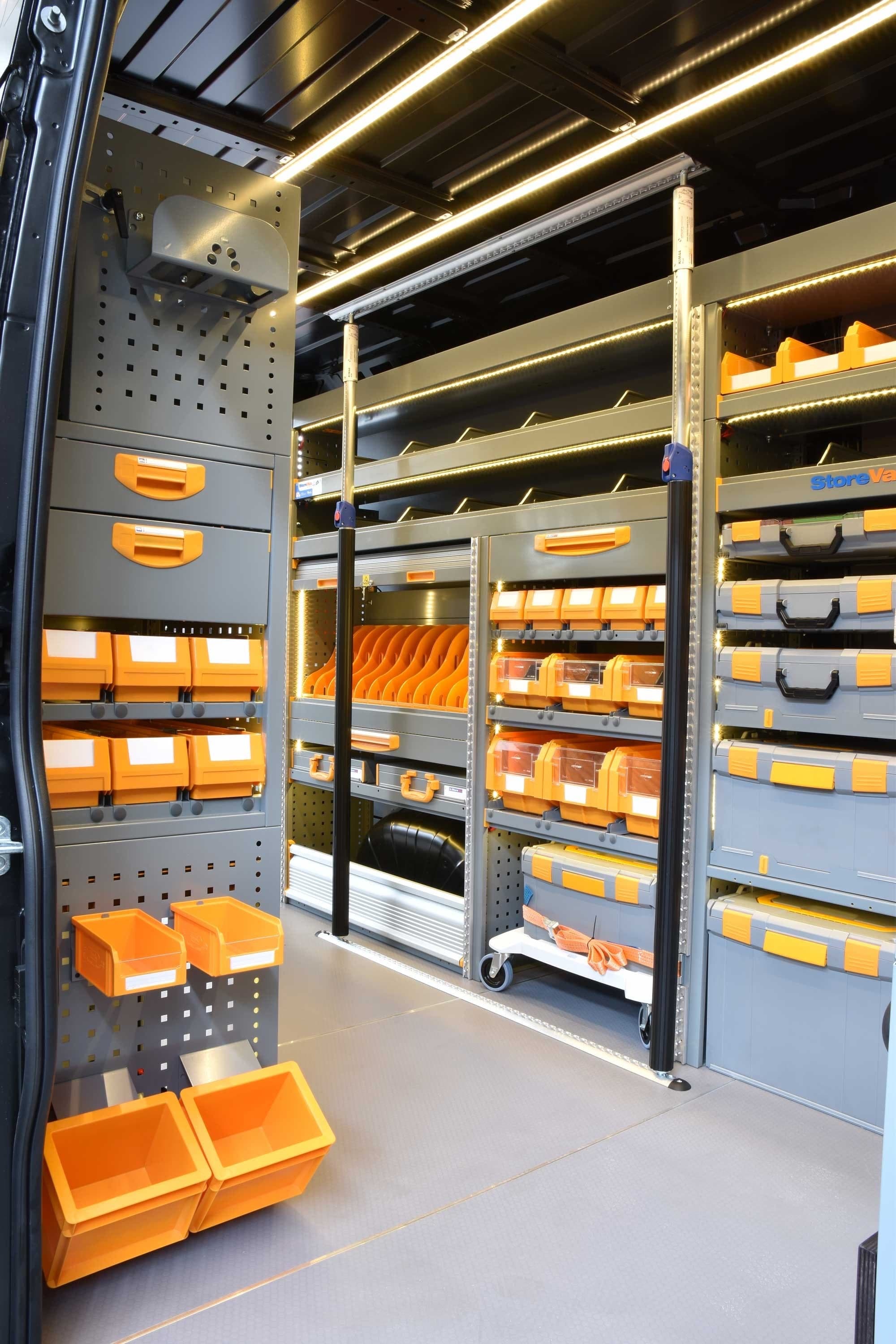 Fourgon entièrement équipé Store Van : rayonnages à bacs orange des deux côtés, coffrets à outils et éclairage LED en toiture