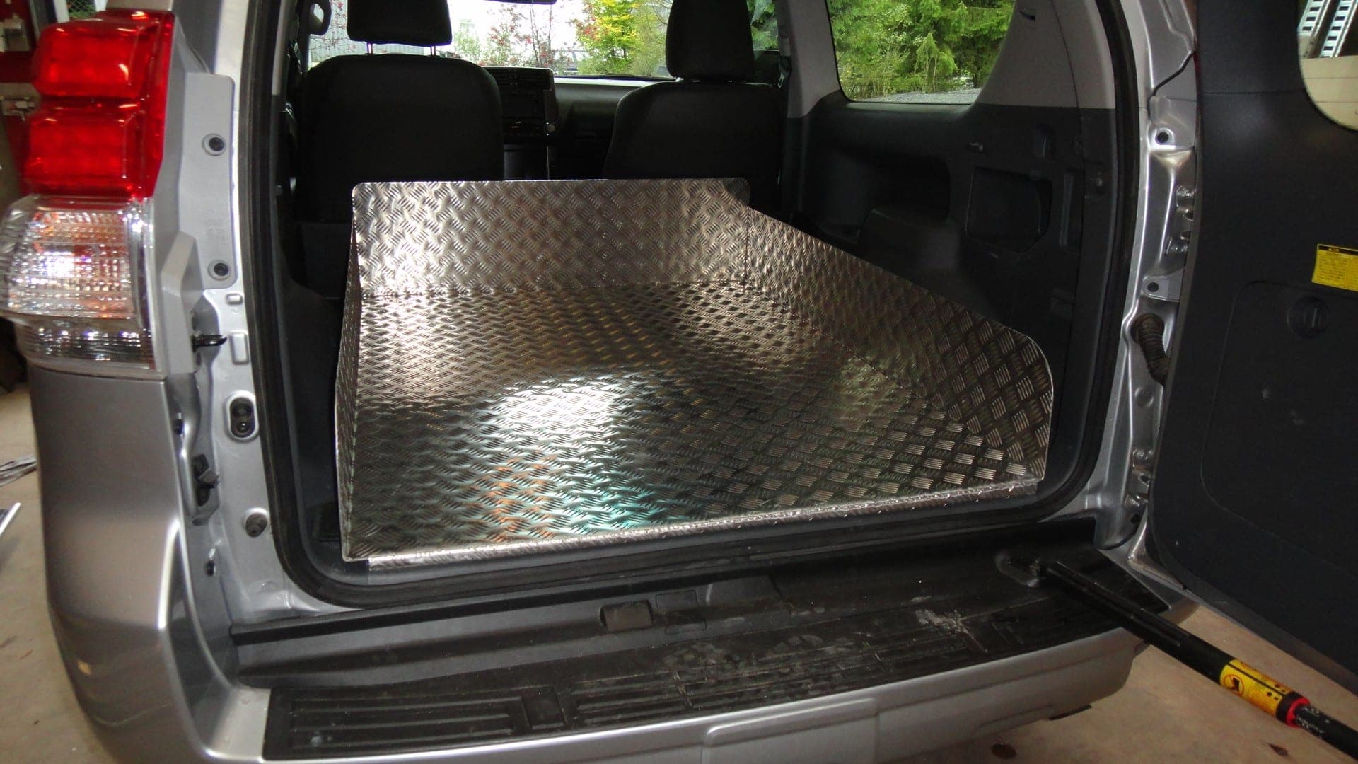Coffre d’un utilitaire compact équipé d’un plancher en tôle larmée aluminium découpé sur mesure