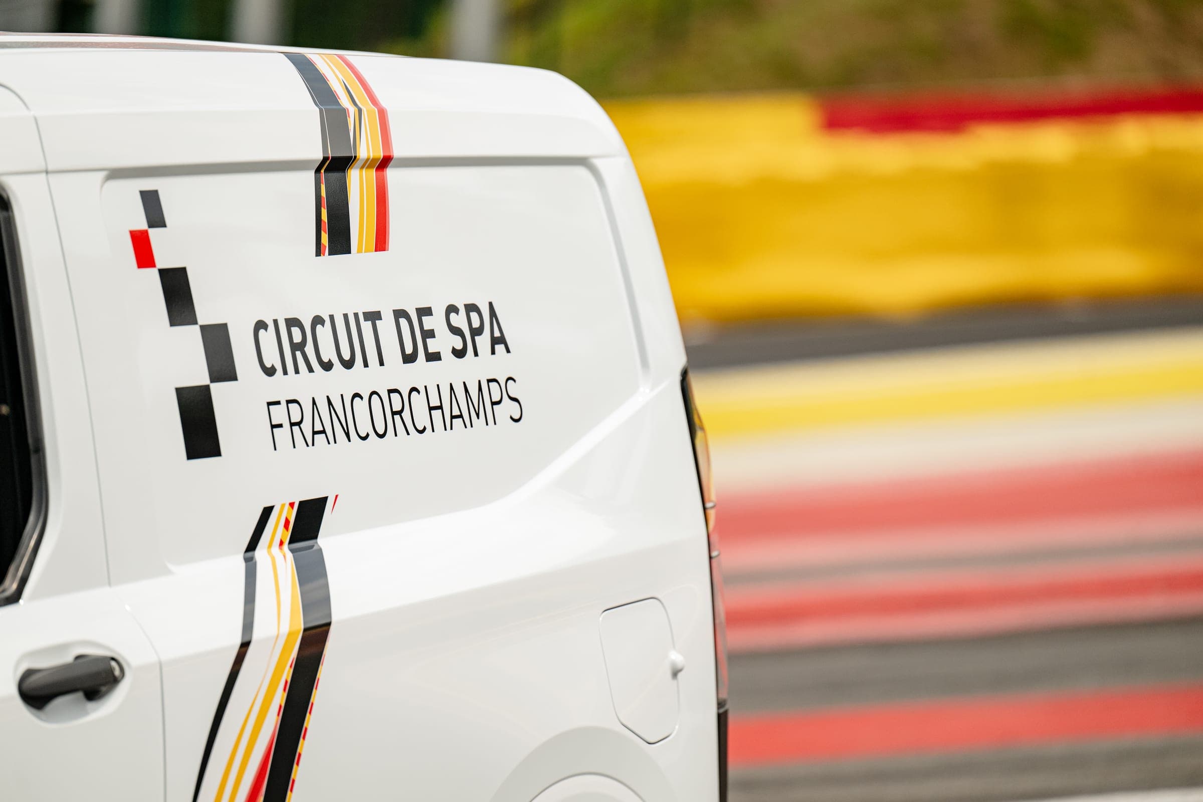 Gros plan du lettrage Circuit de Spa-Francorchamps posé sur le flanc d’un fourgon blanc