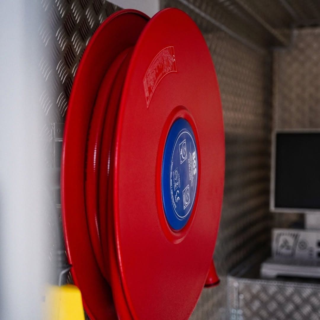 Dévidoir incendie rouge fixé sur une paroi en tôle aluminium larmée de la cellule MD Safety