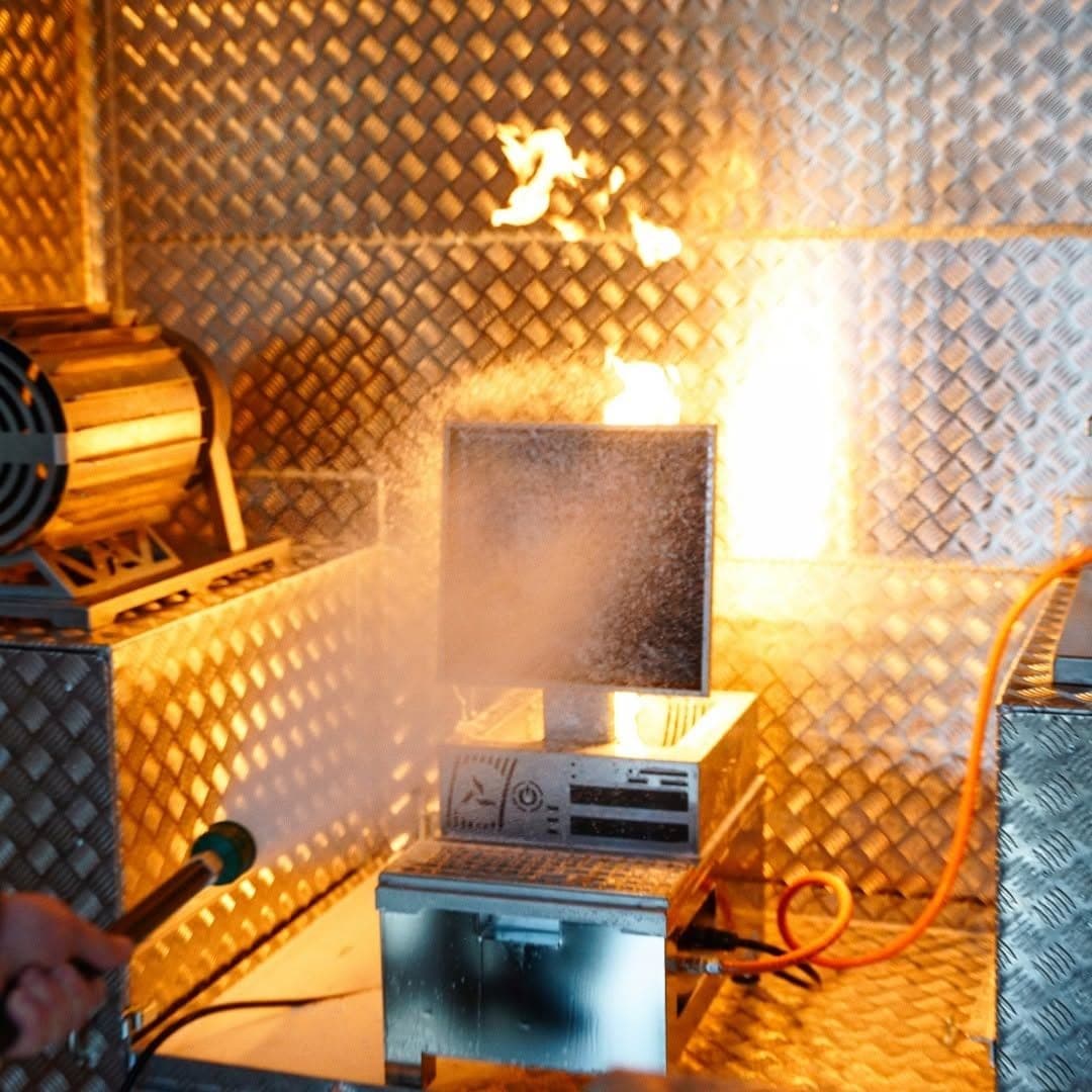 Exercice d'extinction dans la cellule MD Safety, jet d'eau dirigé vers un faux poste informatique en feu