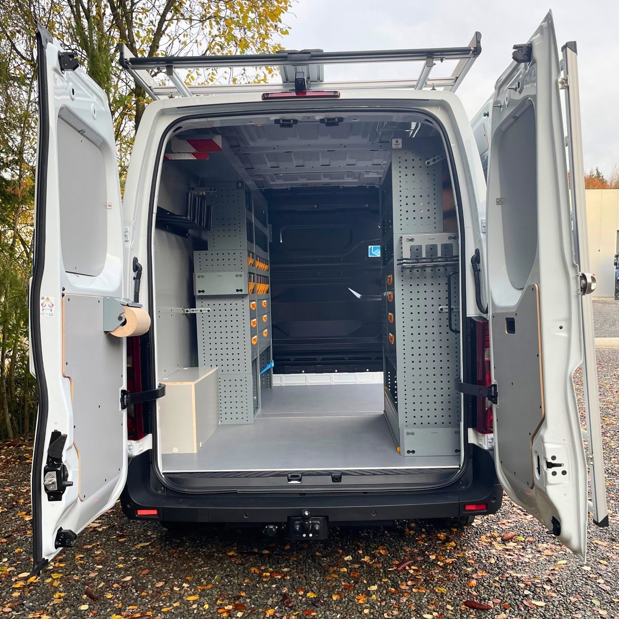 Utilitaire d'Olsen Engineering portes arrière ouvertes, étagères Store Van des deux côtés, plancher gris, galerie de toit et échelle