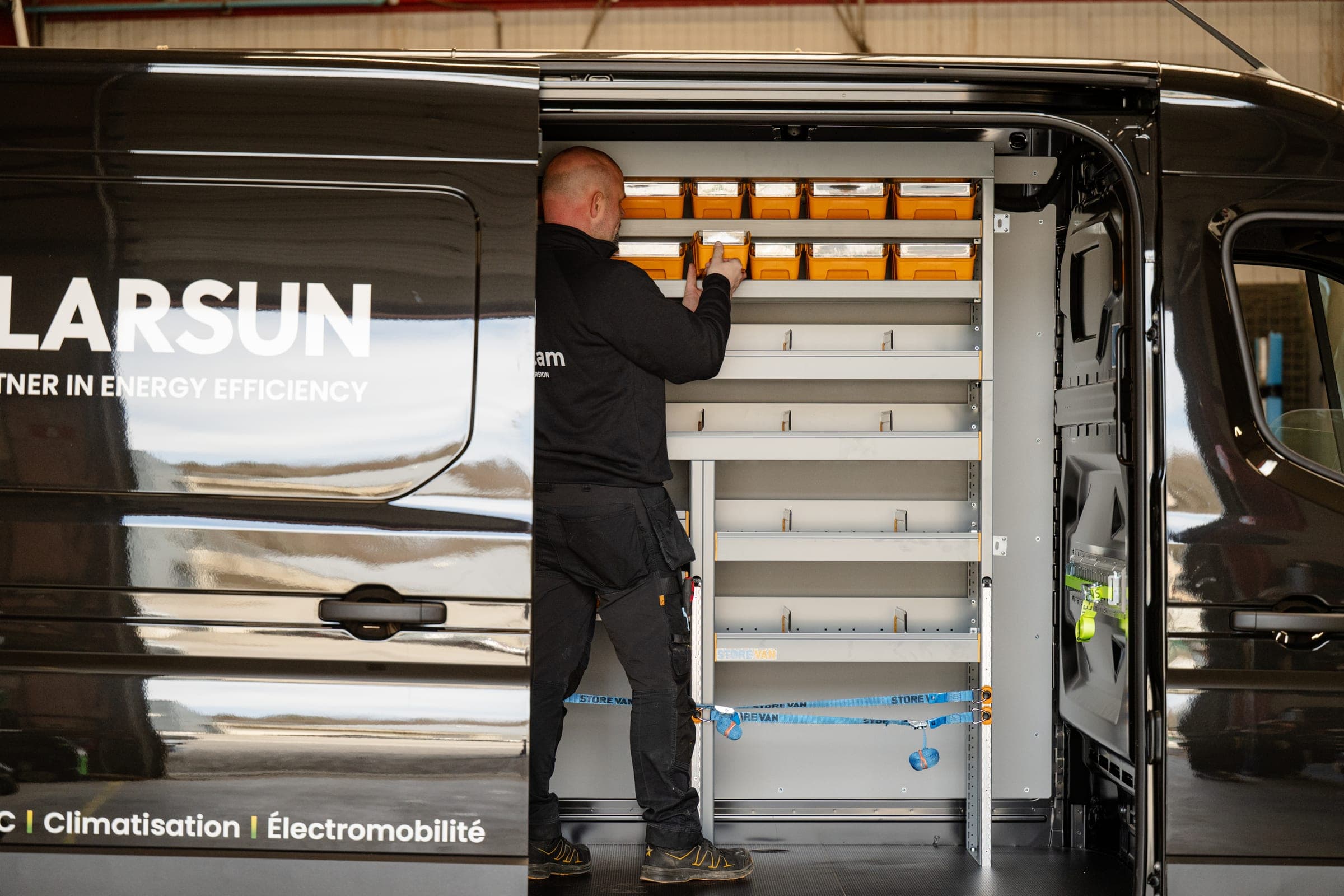 Technicien Amecam installant des bacs à bec dans le rayonnage du Renault Master Polarsun