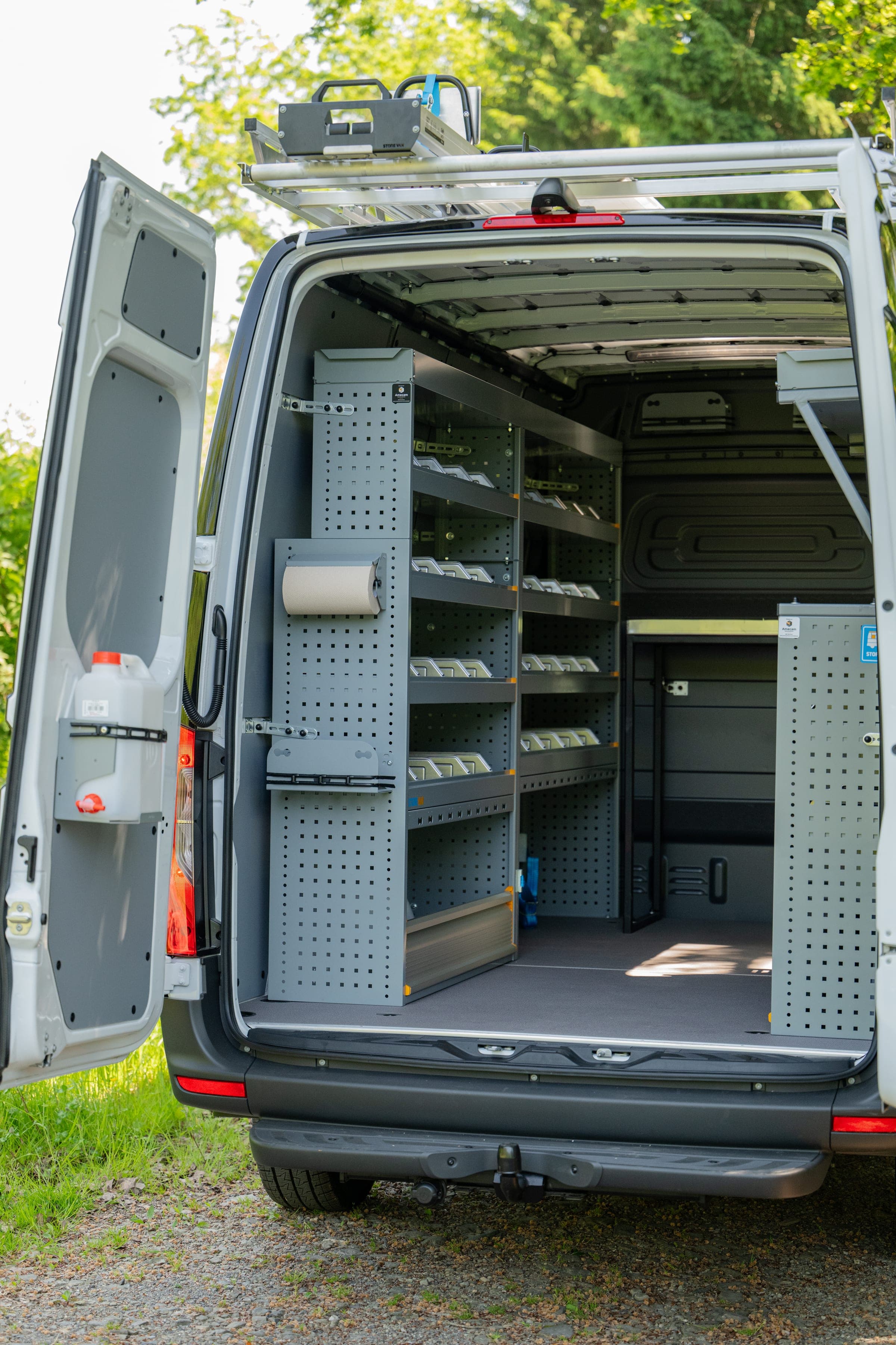 Mercedes Sprinter portes arrière ouvertes sur un rayonnage à étagères et un panneau perforé