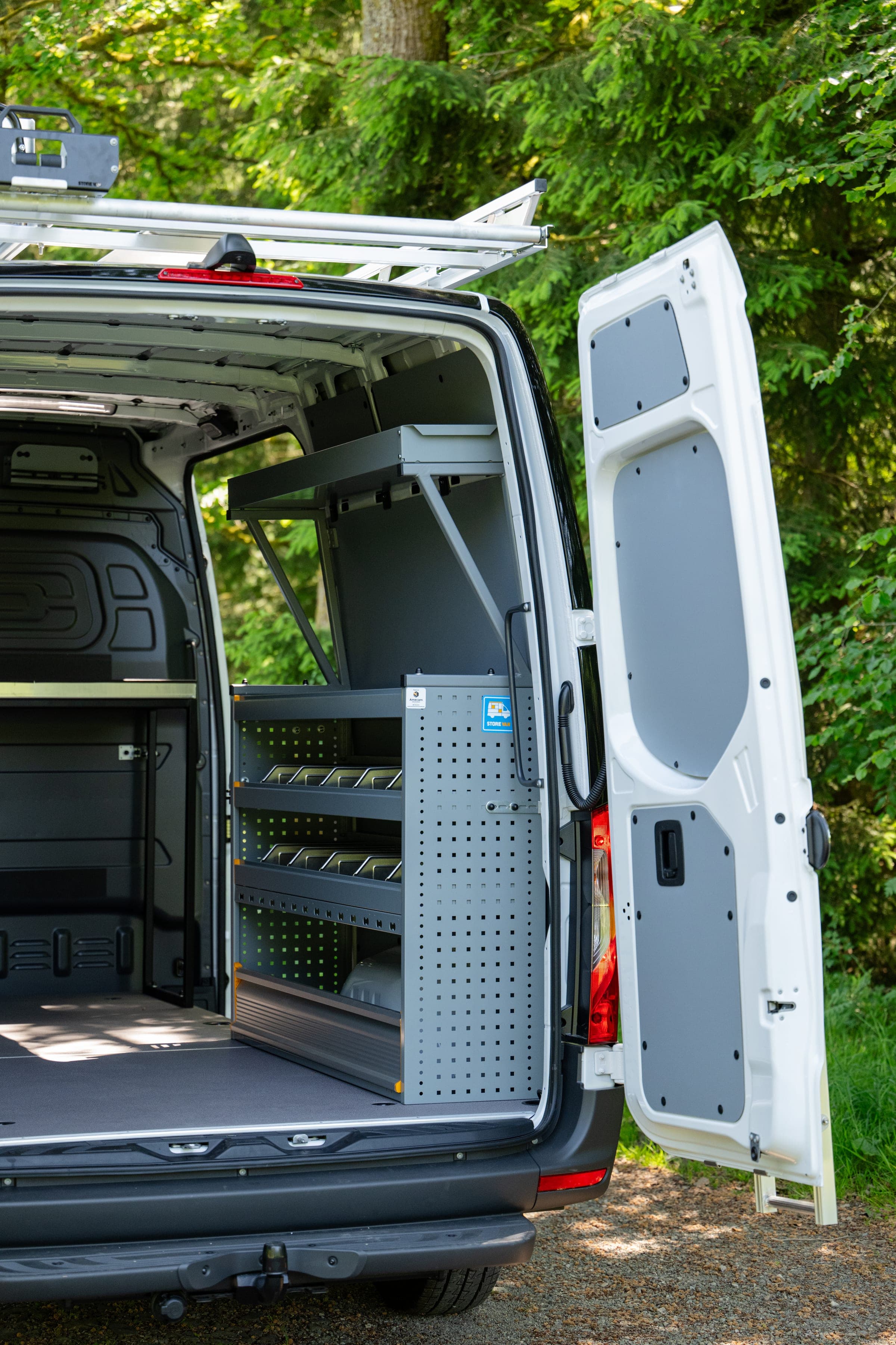 Fourgon Mercedes Sprinter portes arrière grandes ouvertes sur son rayonnage latéral en aluminium